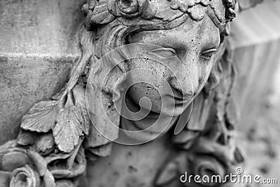 Vintage plaster face of a young woman with leaf hair on the wall. Stock Photo