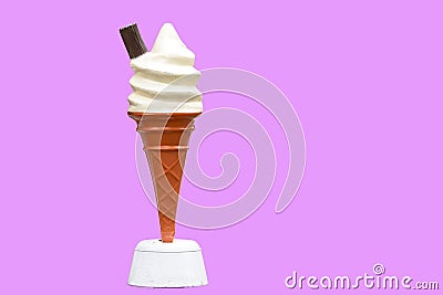 Vintage plastic promotional UK ice cream cone with vanilla whipped ice cream and a chocolate flake with a pink background in UK Stock Photo