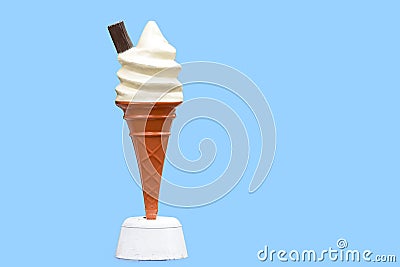 Vintage plastic promotional UK ice cream cone with vanilla whipped ice cream and a chocolate flake with a blue background in UK Stock Photo