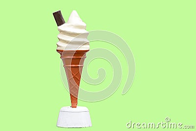 Vintage plastic promotional UK ice cream cone with vanilla whipped ice cream and a chocolate flake with a green background in UK Stock Photo