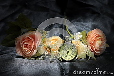 Vintage pocket clock with rose flower on black fabric background. Love of time concept. still life style Stock Photo