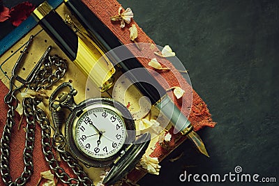 Vintage pocket watch and brass pen on old book. Stock Photo