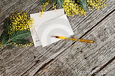 Vintage post cards mock up with yellow flowers mimosas and vintage pen ink on grey wooden background Stock Photo