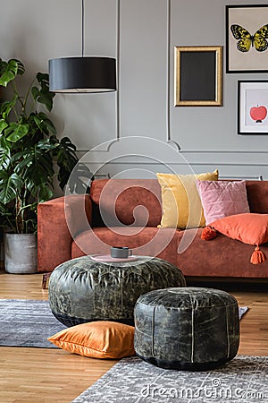 Vintage poufs in trendy eclectic living room interior with brown couch Stock Photo