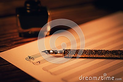 Vintage quill pen on blank music notes sheet Stock Photo