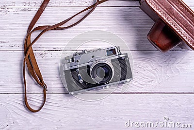 Vintage rangefinder film camera with leather case on white wooden table Stock Photo