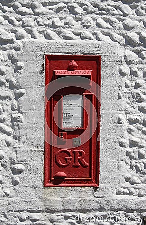 Vintage red UK postbox set in a white wall Editorial Stock Photo