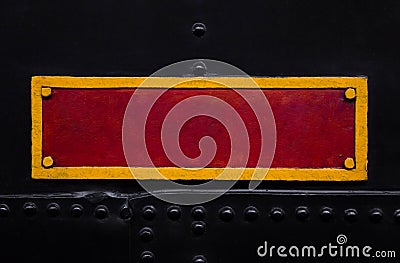 Vintage red and yellow metal plate on the old train. Textured background. Close shot. Stock Photo