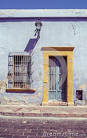 Vintage retro House Exterior and Front Door Seen on a Mexico Street on yellow and blue Editorial Stock Photo