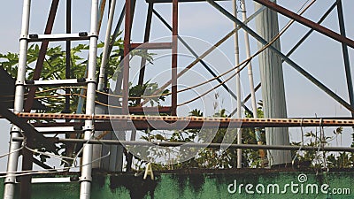 Vintage Rusty Clothes Rack with Old Metal Ladders over Dirty Green Wall Stock Photo