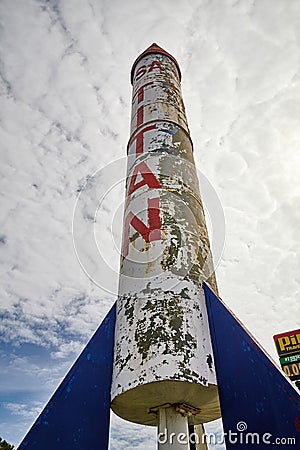 Vintage Saturn Rocket Structure with Blue Fins against Cloudy Sky Editorial Stock Photo