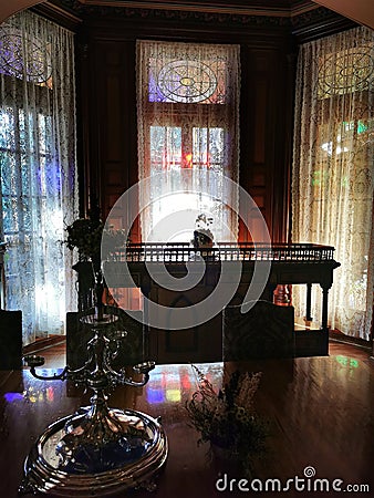 Vintage silver candelabra with triple window on the background at Larnach Castle in New Zealand Editorial Stock Photo