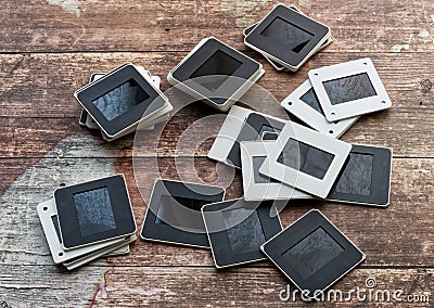 Vintage slides isolated on wooden background. Retro style technology Stock Photo