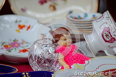 Vintage souvenir doll and porcelain dishes in a market Stock Photo