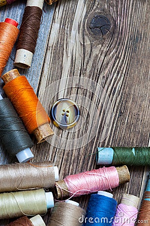 Vintage spools with multi colored threads and old button Stock Photo
