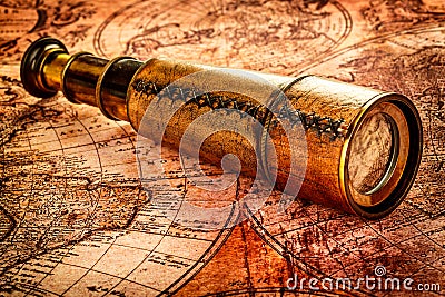 Vintage spyglass lies on an ancient world map Stock Photo