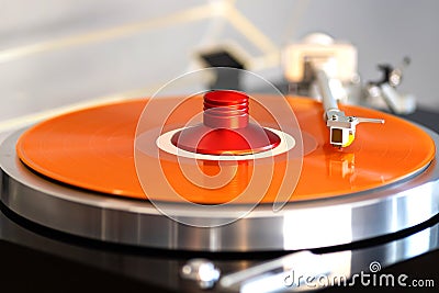 Vintage Stereo Turntable Record Player Tonearm Above Orange Colored Vinyl Stock Photo