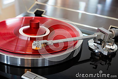 Vintage Stereo Turntable Record Player Tonearm Above Red Colored Vinyl Stock Photo