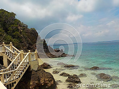 Vintage stone stairs on the edge of the rocks over the blue ocean, Malaysia Stock Photo