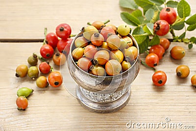 Vintage striped box of rose hip fruits on wooden table Stock Photo