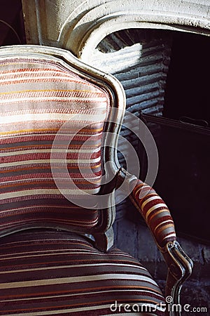 Vintage striped chair in fire place Stock Photo