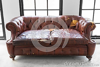 Vintage style . Defective old leather sofa on white room Stock Photo