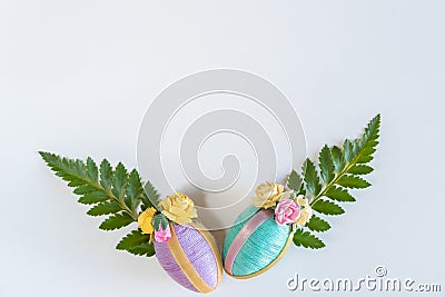 Vintage style handmade pastel Easter eggs and fern leaves on solid white background Stock Photo