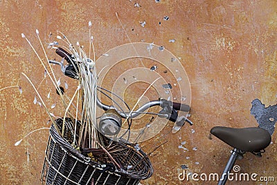 Vintage style old bicycle with basket front of vivid color wall Stock Photo