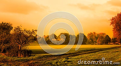 Vintage style warm tones water-colored idyllic autumn sunrise over a rural peaceful landscape Stock Photo