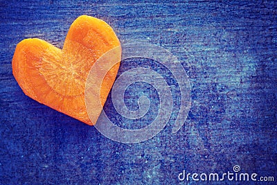 Vintage stylized heart made of carrot on grunge background. Stock Photo