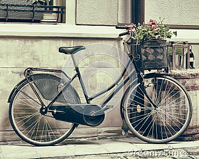 Vintage stylized photo of Old bicycle carrying flowers Stock Photo