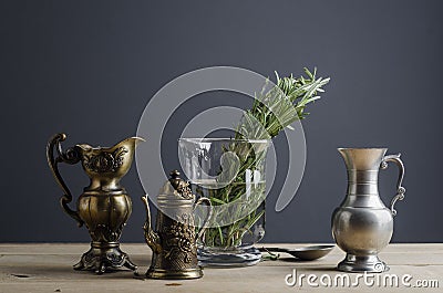 Vintage tableware with glass vase and rosemary on wooden table Stock Photo