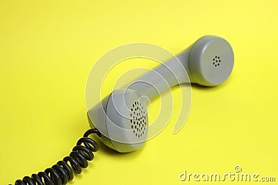 Vintage telephone receiver and cord on yellow background Stock Photo