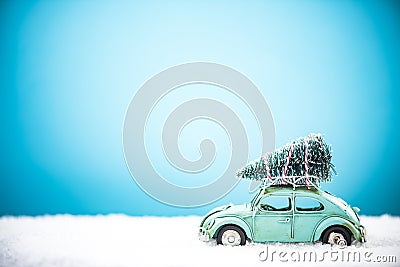 Vintage toy car carry Christmas tree in snow Stock Photo