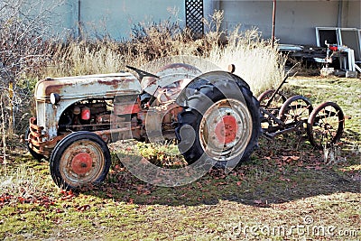 Vintage tractor and implement in front of barn Stock Photo