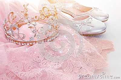 Vintage tulle pink chiffon dress, crown and silver shoes on wooden white floor Stock Photo