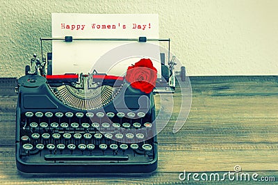 Vintage typewriter with red rose flower. Happy Womens Day Stock Photo