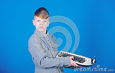Vintage typography. Cute boy having typing machine. Small kid with vintage typewriter. Smart child using machanical Stock Photo