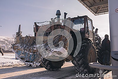 Vintage ussr tractor on petrolium station with chain winter time Editorial Stock Photo