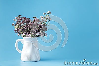 Vintage Vase with a bouquet of blossoming oregano Stock Photo
