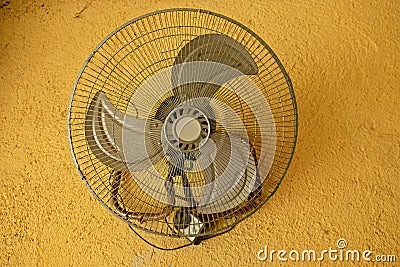 vintage ventilator on yellow concrete wall Stock Photo