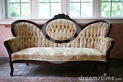 Vintage Victorian High Cameo Back Floral Sofa with Carved Mahogany Woodwork Stock Photo