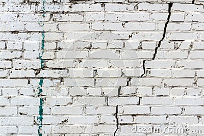 Vintage white brick wall with a deep crack and spots of paint. Abstract background Stock Photo