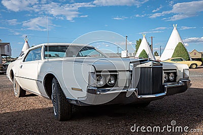 Vintage white Lincoln Continental Mark IV car parked in front of a wigwam motel Editorial Stock Photo