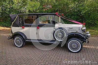 Vintage white wedding car with red ribbons Editorial Stock Photo