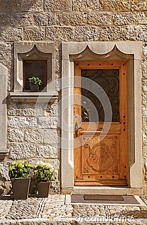 Vintage wood medieval door in rural stone wall house, Switzerlan Stock Photo