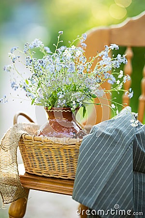 Vintage wooden chair with ceramic vase and bouquet of forget-me-not`s on it. Close up Stock Photo