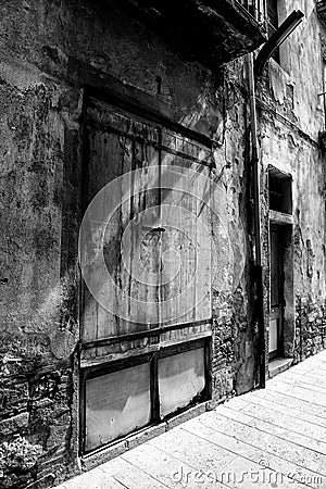 Vintage wooden door spotlit by sunlight, black and Stock Photo