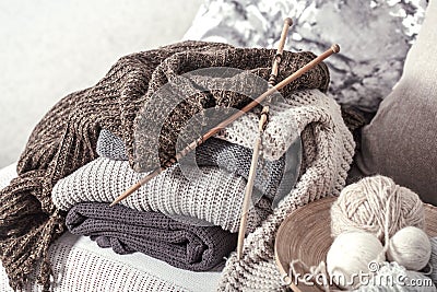 Vintage wooden knitting needles and threads for knitting on a cozy sofa with pillows and sweaters Stock Photo