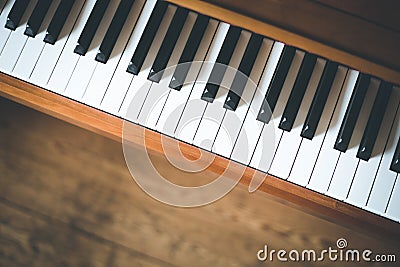 Vintage wooden piano. Keys in the foreground, wooden floor with text space in the blurry background Stock Photo